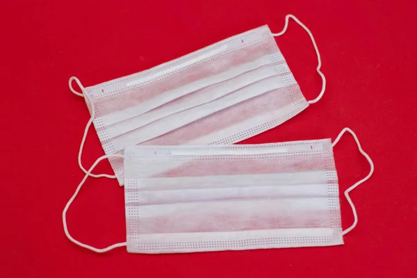 Disposable medical mask on a red background. Epidemic Virus Protection, the photo