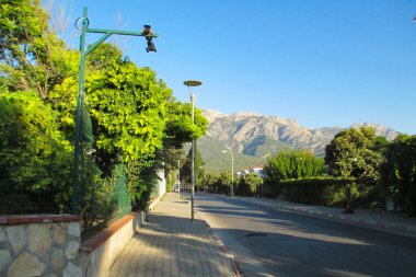 Tatil köyündeki boş yol. Terk edilmiş yaz tatilleri, dağlar ve tropikal yeşillik, fotoğraf.