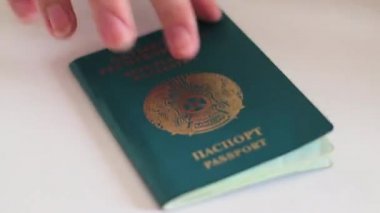 Rusya ve Kazakistan pasaportları, sınır ülkeleri. El, pasaportları masaya koyar.