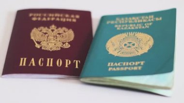 Rusya ve Kazakistan pasaportları, sınır ülkeleri. El, pasaportları masadan alır.