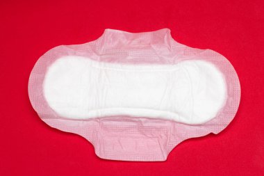 Kırmızı arka planda kadın hijyenik ped. Adet sırasında hijyen.