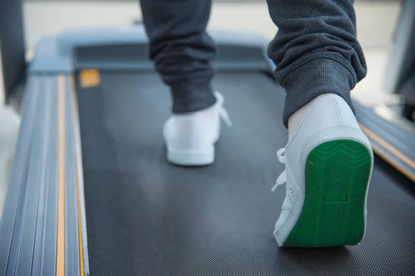 Jambes en cours d'exécution sur tapis roulant, exercice au centre de remise en forme ou gymnase — Photo