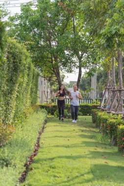 yaşlı adam ve kadın parkta koşu egzersiz, gülümseyen ve açık çimenlerin üzerinde çalışıyor. Sağlık kavramı