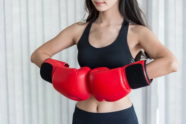 Mujer en ropa deportiva negra y guantes de boxeo rojos listos para luchar —  Fotos de Stock