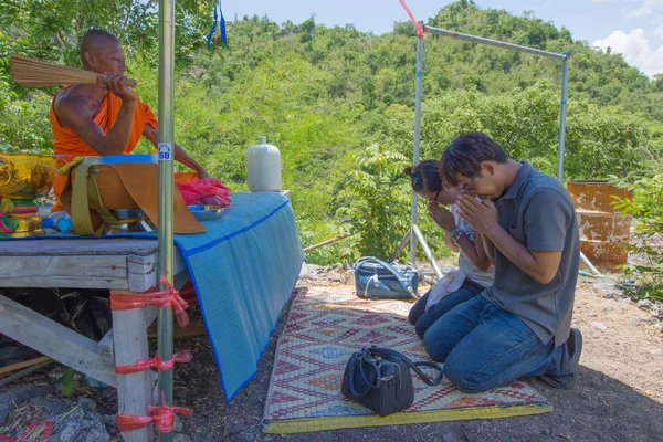 Bir keşiş kutsal su turistlere Wat Ban Tham Tapınak, Tayland serpilir.