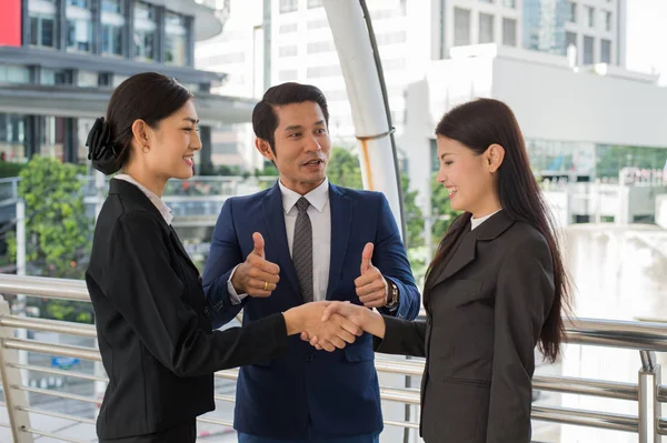 iş adamı yukarı ve anlaşma ya da onların firmaları, şirketleri, şirketler arasında sözleşme imzalamak için onların anlaşma gösteren için el sıkışan iki iş kadını göster. başarı kavramı