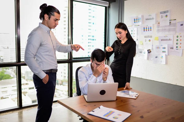 Hombre de negocios está nervioso y puso su mano en la cabeza porque su jefe y colega muy agrado y señalar los dedos en él. El concepto de errores de negocio . — Foto de Stock