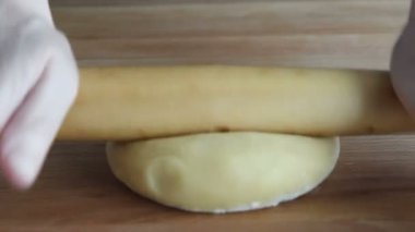 Bir kesme tahtası üzerinde hamur yoğurma eller