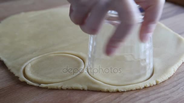 Manos femeninas cortando círculos de masa para preparar galletas — Vídeo de stock