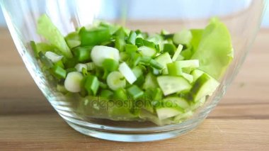 Closeup düşen çevrelerin cam kase üzerinde yeşil soğan