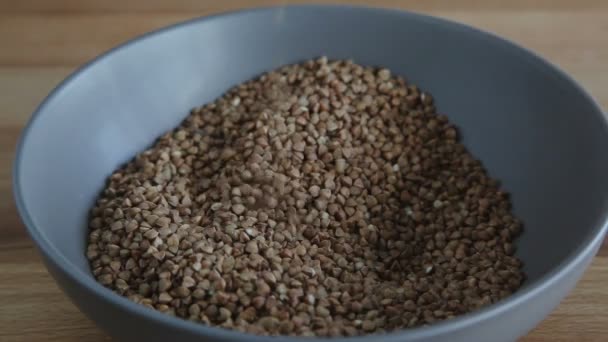 Female hands pours buckwheat grain — Stock Video