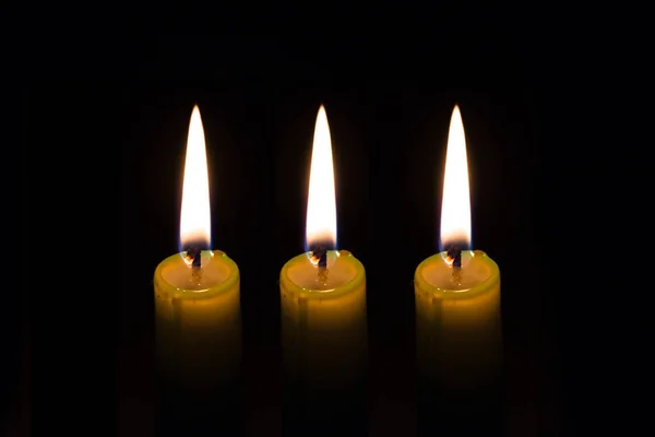 Three candles on black background