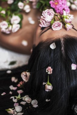 Gül ve yaprakları kaplı güzel kadın