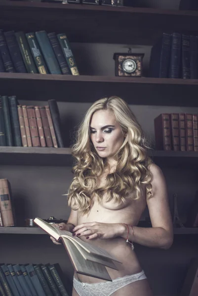 Hermosa mujer leyendo libro en la biblioteca —  Fotos de Stock