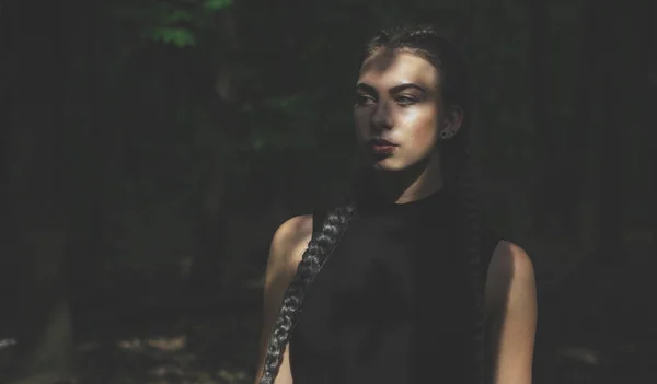 Young woman in forest looking away