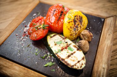 Taş bir tahta üzerinde ızgara sebze