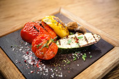 Taş bir tahta üzerinde ızgara sebze