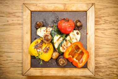 Taş bir tahta üzerinde ızgara sebze