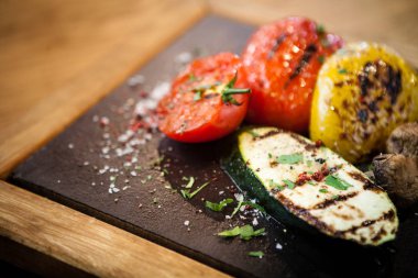 Taş bir tahta üzerinde ızgara sebze