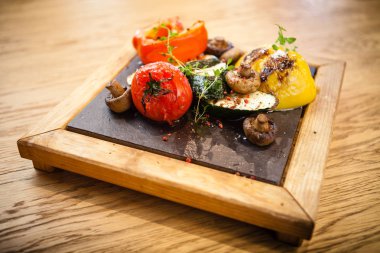 Taş bir tahta üzerinde ızgara sebze