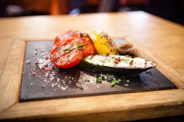 Taş bir tahta üzerinde ızgara sebze