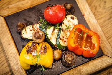 Taş bir tahta üzerinde ızgara sebze