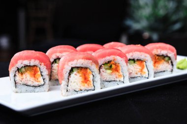 ton balığı, yumuşak Yengeç, balık, uçan balık yumurtası ve baharatlı krem peynir rulo sunulan bir plaka üzerinde