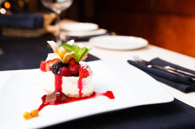 Cheesecake beyaz plaka üzerinde yabani çilek ile