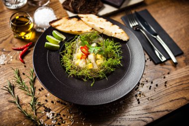 Scallop ceviche siyah kasede sıvı buz dumanıyla servis edilir