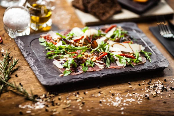 Rundvleescarpaccio geserveerd op een bord in restaurant — Stockfoto