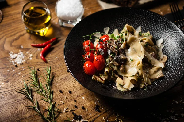 Black Angus Pasta served in a black bowl in restaurant — Stock Photo, Image