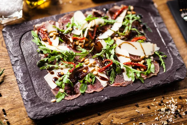 Nötkött carpaccio serveras på en bräda i restaurang — Stockfoto