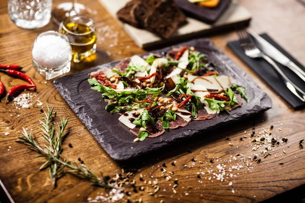 Beef carpaccio served on a board in restaurant — Stock Photo, Image