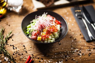 Lokantada siyah bir kasede servis edilen biftekle dürtmek.