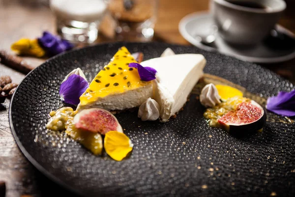 Cheesecake met passievrucht geserveerd op een bord in restaurant — Stockfoto