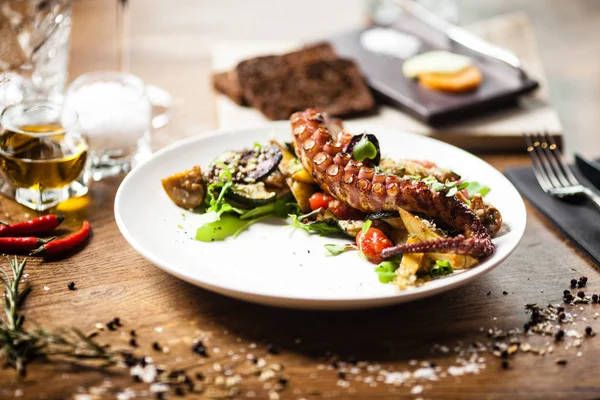 Салат из осьминога подается на тарелке в ресторане — стоковое фото