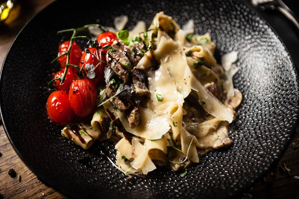 Black Angus Pasta served in a black bowl in restaurant — Stock Photo, Image