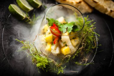 Scallop ceviche siyah kasede sıvı buz dumanıyla servis edilir