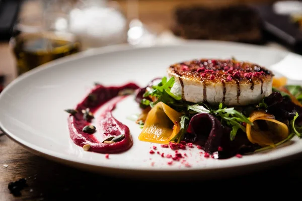 Grilled goat cheese salad served on a plate in restaurant — Stock Photo, Image