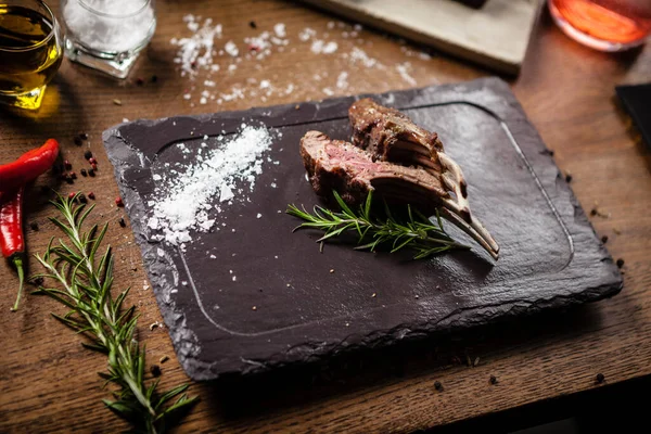 Grilled lamb chops served with a branch of rosemary — Stock Photo, Image