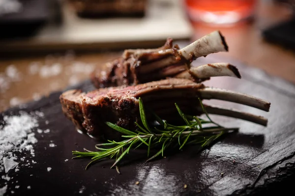 Gegrillte Lammkoteletts serviert mit einem Zweig Rosmarin — Stockfoto