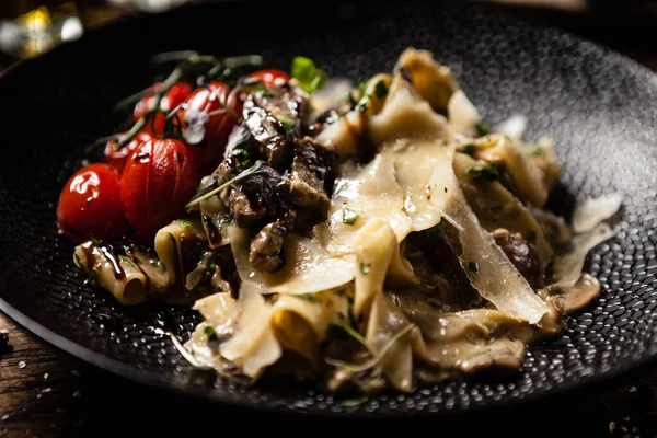 Black Angus Pasta served in a black bowl in restaurant — Stock Photo, Image