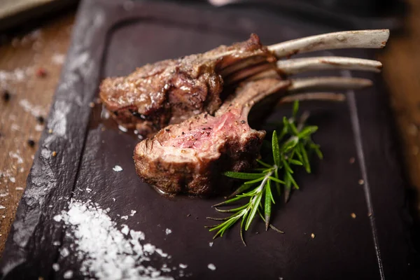 Gegrillte Lammkoteletts serviert mit einem Zweig Rosmarin — Stockfoto