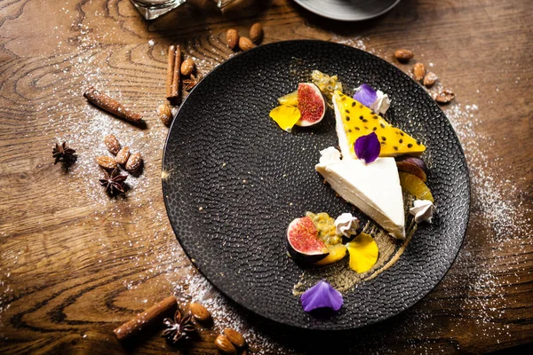 Cheesecake met passievrucht geserveerd op een bord in restaurant — Stockfoto