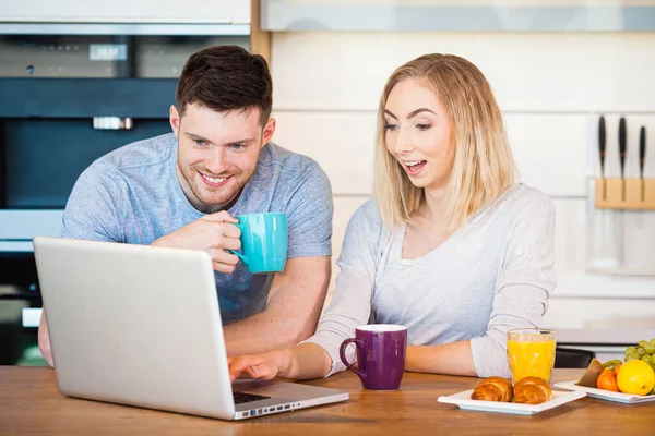 Young happy couple having breakfast at home — Stock Photo, Image
