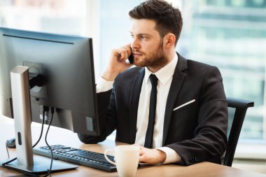 Young businessman in office sitting at his desk