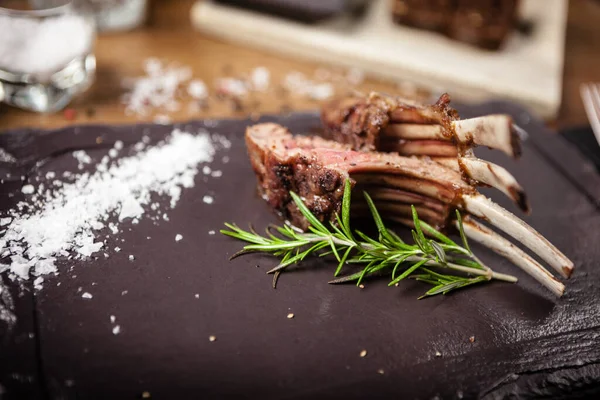 Grilled lamb chops served with a branch of rosemary — Stock Photo, Image