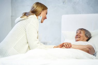 Hastane konseptinde sağlık hizmeti. Kızı yaşlı bayanı hastanede ziyaret ediyor.