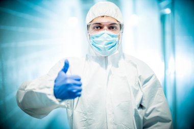 Corona virüsü konsepti. Erkek doktor baş parmağını gösteriyor.