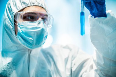 Corona virüsü konsepti. Erkek doktor test tüpünü inceliyor.